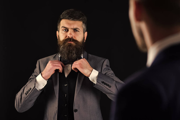 Meeting of reputable businessmen, black background. Man with beard on serious face, ties bow tie before meeting. Business meeting concept. Businessmen, business partners in formal wear, defocused. - Фото, изображение