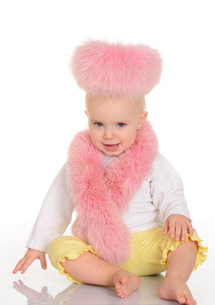cute baby in pink fur sitting on white background - Foto, afbeelding