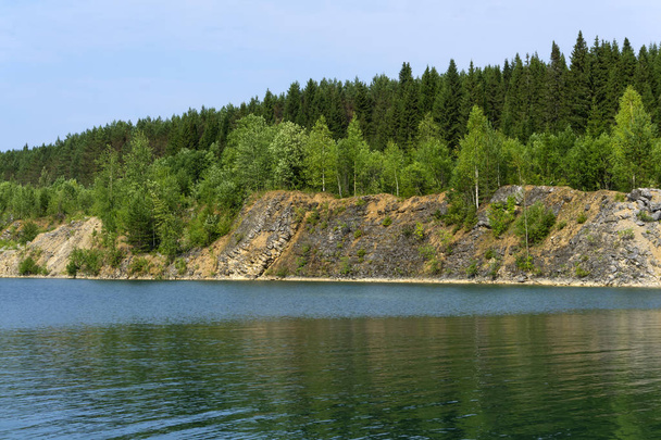 järvi, jossa on metsäiset jyrkät rannat - vedenalainen vanha työstetty louhos
 - Valokuva, kuva