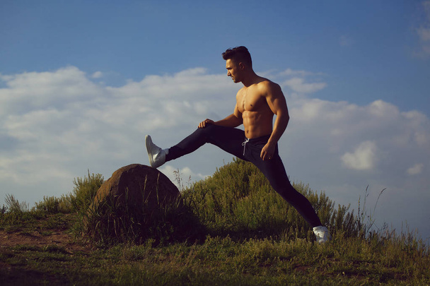 Sexy muscular man on sky background - Фото, изображение