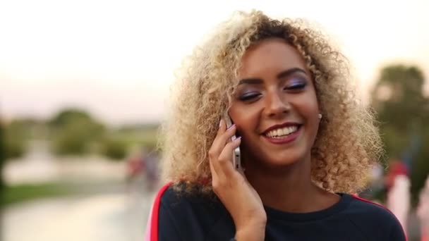 Positivity woman with volumed curly hair talking at call phone and smiling. - Materiaali, video