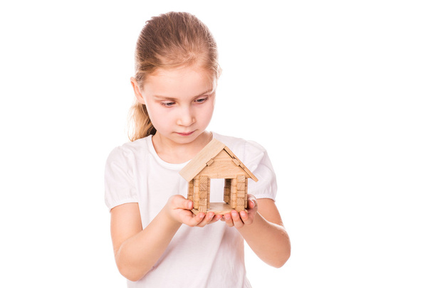 Beautiful little girl holding a toy model house. Buying a house concept. - Foto, Imagem