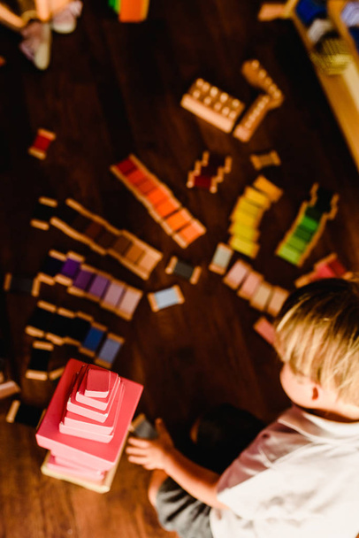 Child at home studying with montessori materials and the pink tower - Valokuva, kuva
