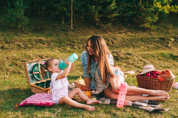 vacation concept, mother and daughter on picnic in park  - Fotoğraf, Görsel