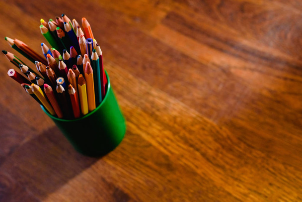 Värilliset kynät täydellä kynällä, lattialla lämmin puu tausta ja vapaata tilaa tekstiä
 - Valokuva, kuva