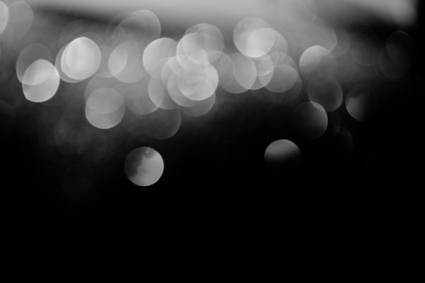 festlich glänzendes silbernes Bokeh auf schwarzem Hintergrund mit Kopierraum - Foto, Bild