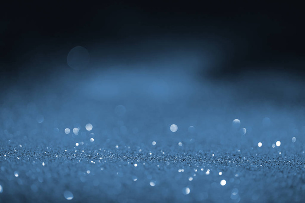 blurred blue glowing glitter on black background - Photo, Image