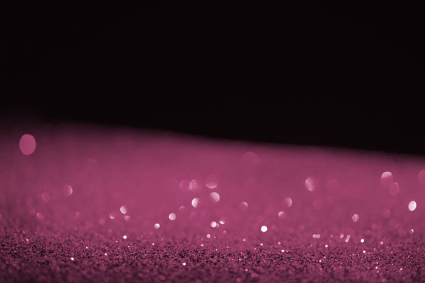 blurred purple glowing glitter on black background - Photo, Image