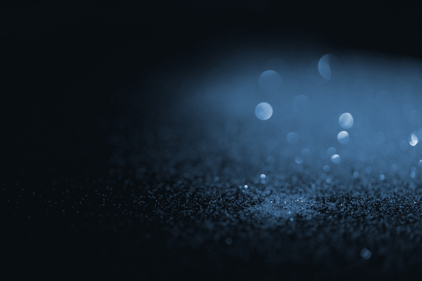 blurred blue glitter on dark background - Fotó, kép
