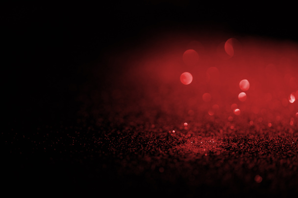 blurred red glitter on dark background - Foto, Bild