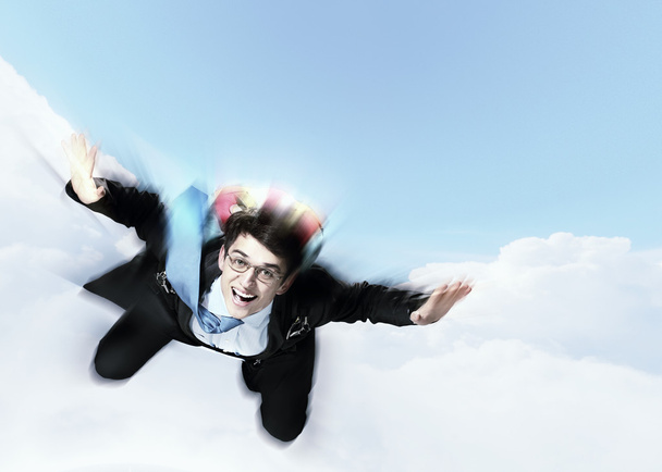 Young businessman flying with parachute on back - Zdjęcie, obraz