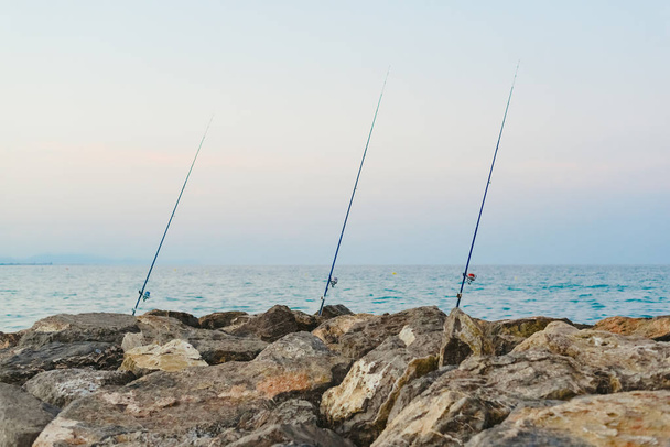 釣り竿海海岸漁師の近くの岩に固定 - 写真・画像