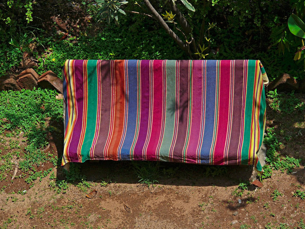 duża Mata jest rozłożona na ławce wykonany Beton cement w ogrodzie - Zdjęcie, obraz