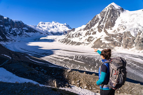 Young female hiker looking at Glacier de Corbassiere. Hiking a mountain trail around Glacier and Grand Combin in Valais Alps (Pennine Alps), Switzerland. - Foto, imagen