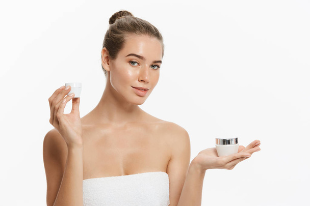 Beauty Youth Skin Care Concept - Beautiful Caucasian Woman Face Portrait holding and presenting cream tube product. Beautiful Spa model Girl with Perfect Fresh Clean Skin over white background - Foto, immagini