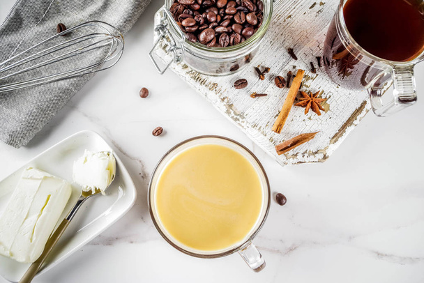 Trendy ketogenic diet food, Bulletproof coffee with milk and butter, white marble background copy space top view - Photo, Image