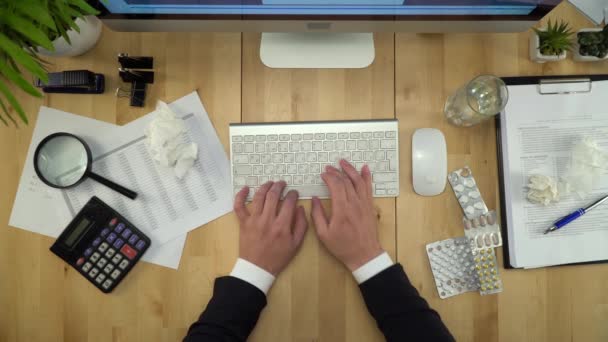 Nemocný obchodní muž pracuje na počítači na pracovišti plochý Lay - Záběry, video