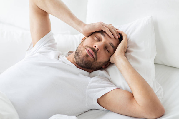 man in bed at home suffering from headache - Foto, Imagen