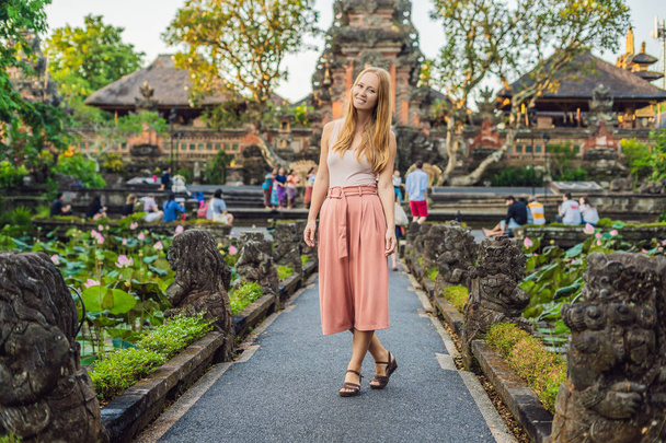 Young woman traveler posing by Pura Taman Kemuda Saraswati Temple, Ubud, Bali, Indonesia - Foto, afbeelding