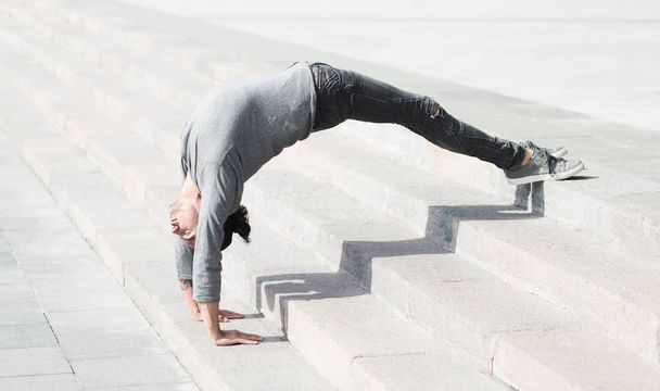 Sporty man doing advanced yoga asana outdoors - Photo, Image