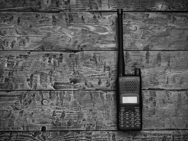 Imagen en blanco y negro de un walkie-talkie sobre una mesa de madera. Instalación de comunicación inalámbrica del pasado
. - Foto, imagen