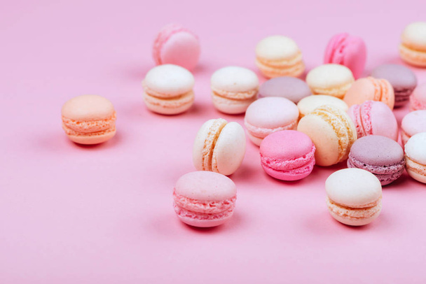 Group of sweet pink and white mini macarons on soft pink paper background with copy space for adding text - Photo, Image