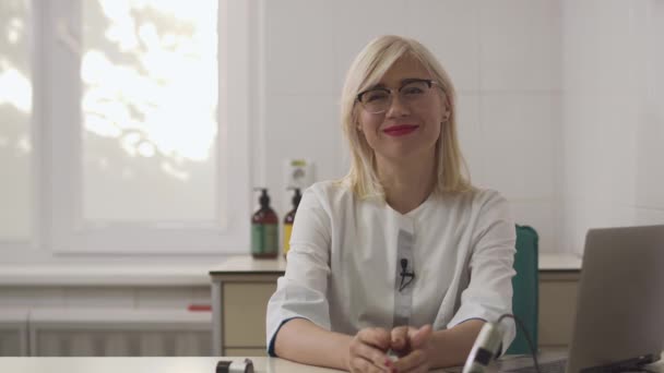 Beautiful dermatologist girl gives an interview at the workplace. - Záběry, video
