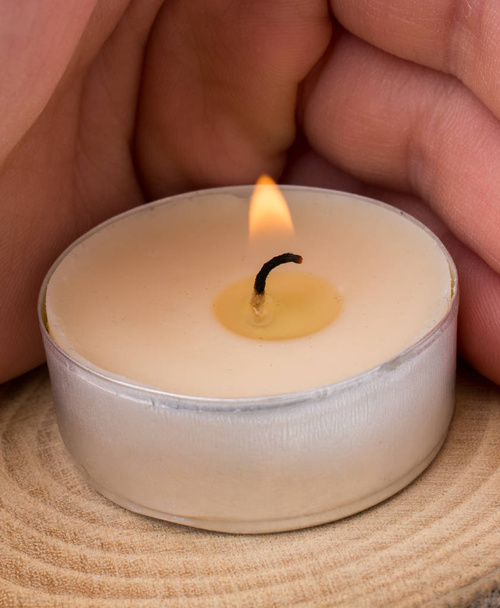 Rukou hořící svíčku na kusu dřeva - Fotografie, Obrázek