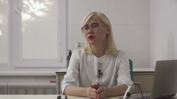 Beautiful dermatologist girl gives an interview at the workplace. - Záběry, video