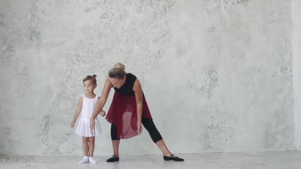 μικρή μπαλαρίνα επαναλαμβάνει την κίνηση στην τάξη μπαλέτου της για τη δασκάλα - Πλάνα, βίντεο
