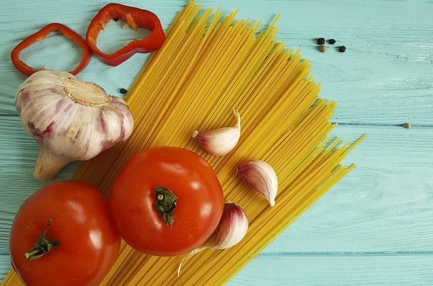 spagetti, paradicsom, fokhagyma, sajt, a kék fa háttér - Fotó, kép