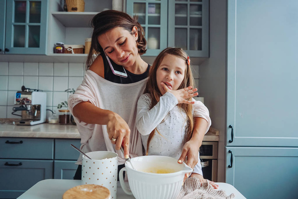 mom teaches her little daughter to cook food - Photo, Image