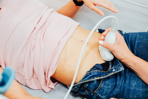 Nainen gynekologi tekee ultraääni skan alaosassa vatsa
 - Valokuva, kuva