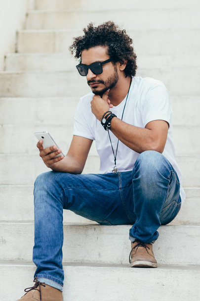 Young black man using cellphone on the street - Fotó, kép