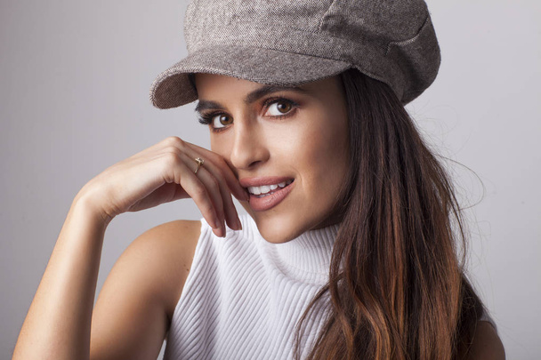 Beautiful brunette in the hat in front of camera. - Photo, Image