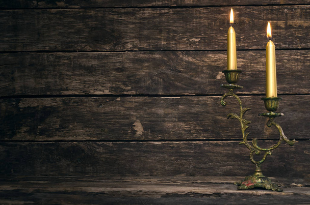Burning candle on aged wooden table background. - Foto, Bild