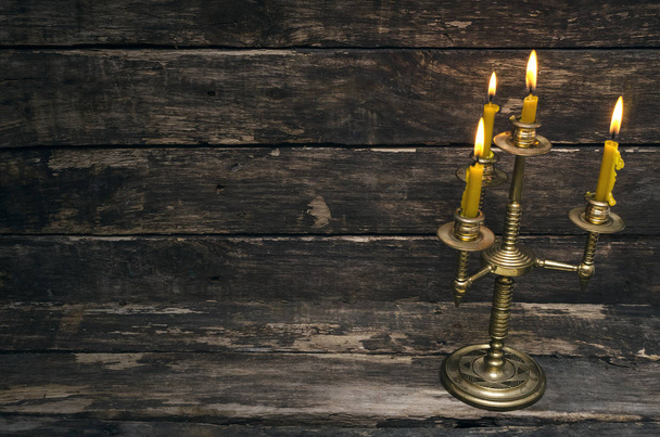 Burning candle on aged wooden table background. - Foto, Bild