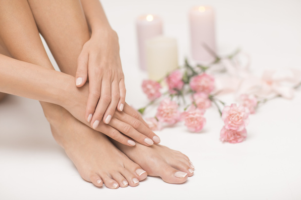 The picture of ideal done manicure and pedicure. Female hands and legs in the spa spot. - Fotó, kép
