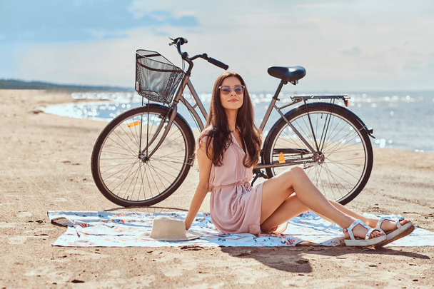 glückliche junge Frau in Sonnenbrille und Kleid genießt Urlaub am Strand. - Foto, Bild