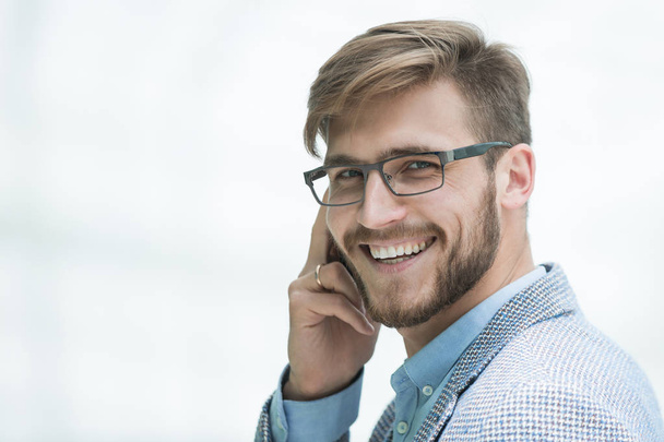 close up.smiling businessman talking on smartphone - Photo, Image
