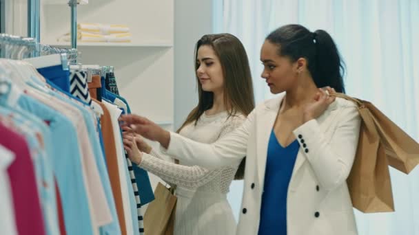 Jonge gelukkig vrouwen winkelen kleding in de winkel - Video
