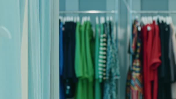 junge Frau probiert Kleidung in der Umkleidekabine eines Geschäfts an  - Filmmaterial, Video