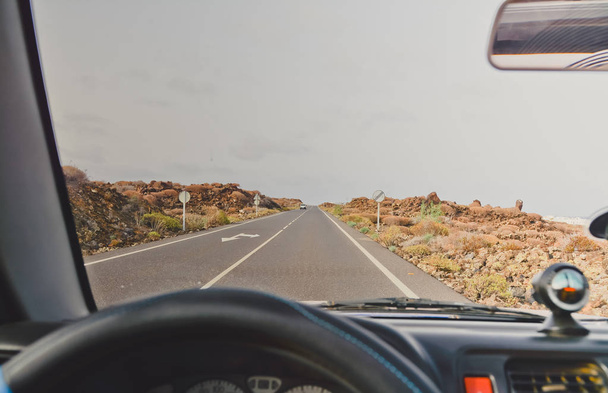 Man rijdt auto via de bergen en de Oceaan. Kijk op lege asfalt weg doorheen een autoruit - Foto, afbeelding