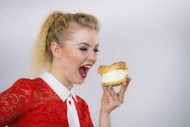 Woman holding sweet cupcake cake dessert with cream, she wants to eat it. - Foto, Bild