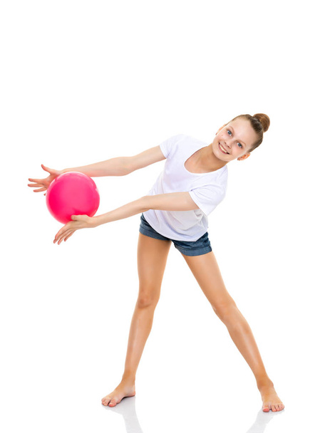Chica gimnasta realiza ejercicios con la pelota. - Foto, imagen
