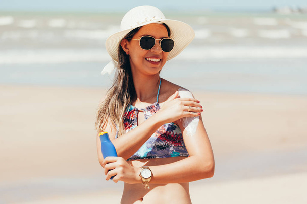 Sunscreen, sunblock. Woman putting solar cream on shoulder smiling beautiful summer day. Skincare. Girl applying sun cream - Valokuva, kuva