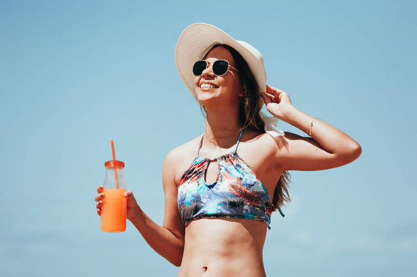 Fashion woman drinking cocktail on the beach - Foto, Imagen