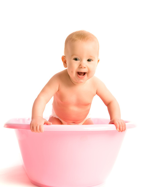 baby in a pink tub for bathing isolated - Фото, изображение