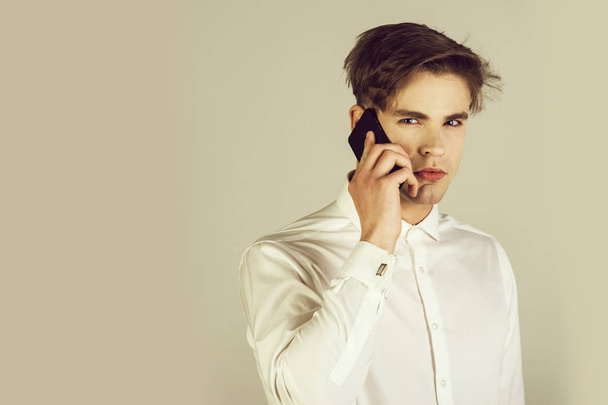 handsome man in white shirt with cufflink speaking on phone - Foto, afbeelding