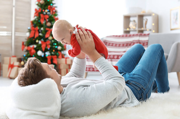 Happy couple with baby in Christmas hats at home - Фото, зображення